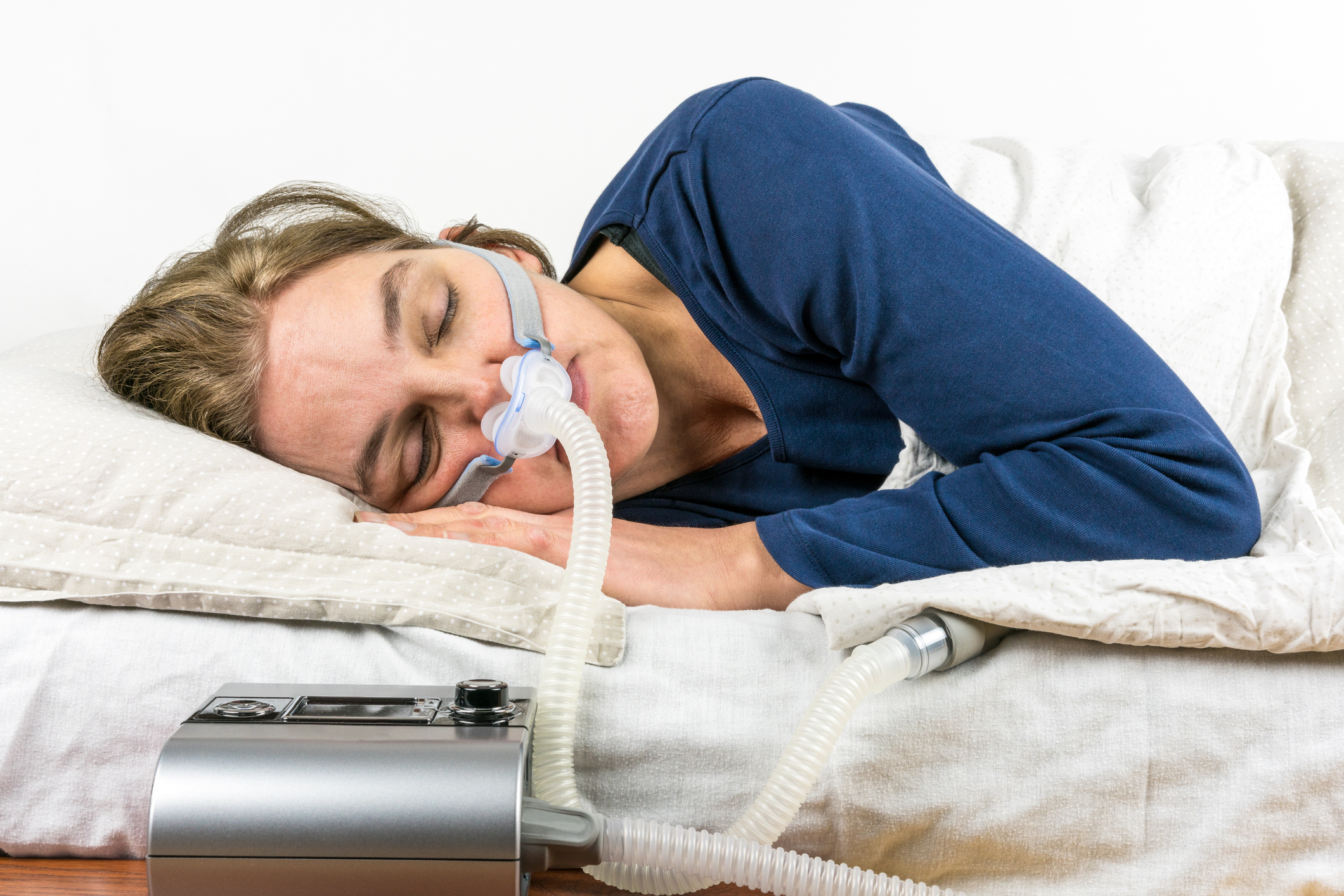 Female Adult sleeping on side with CPAP machine attached
