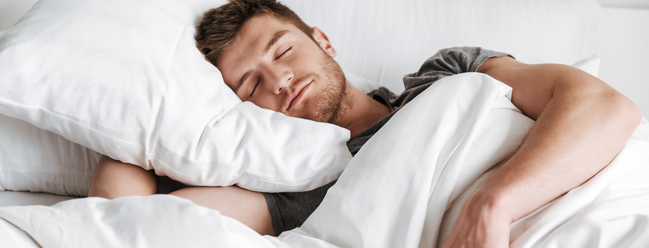 Adult Man Sleeping in bed on his side using comfy pillows